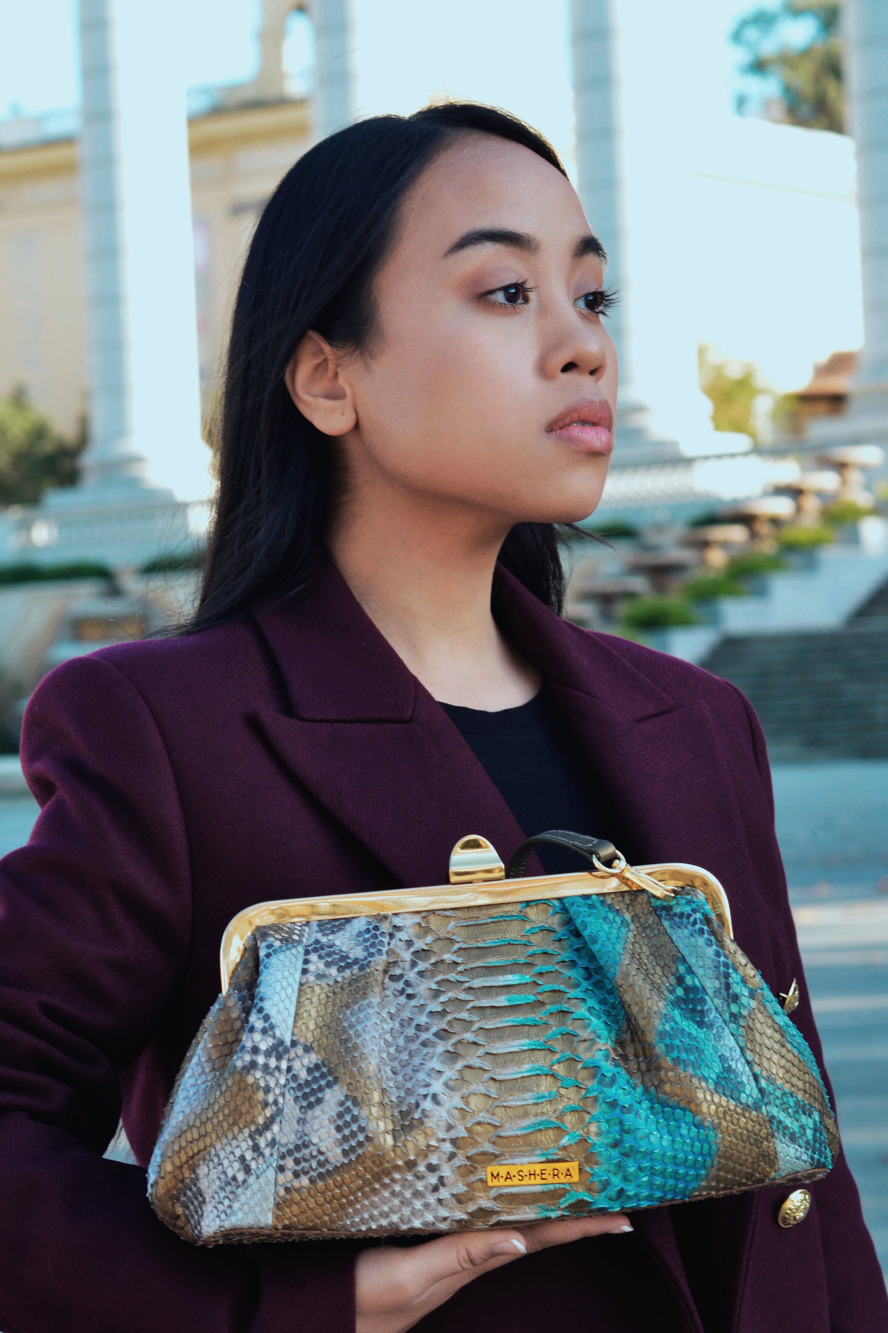 Modelo posando con el bolso COFRE turquesa elaborado en piel pitón