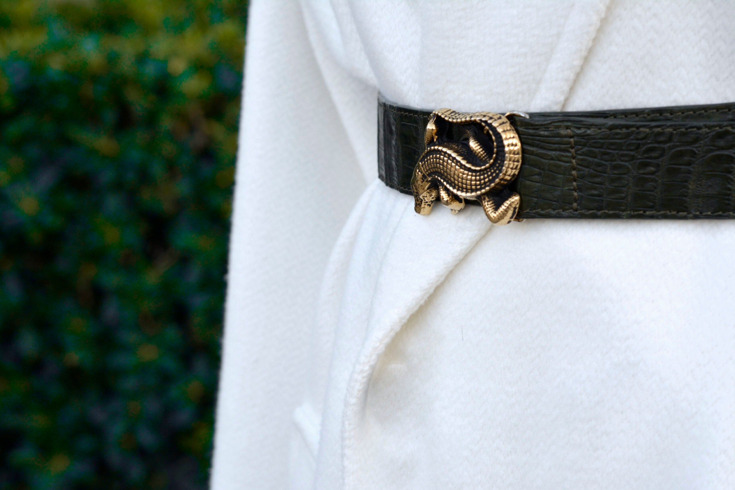 Primer plano de modelo luciendo cinturón CAIMÁN - accesorio distintivo en cocodrilo genuino