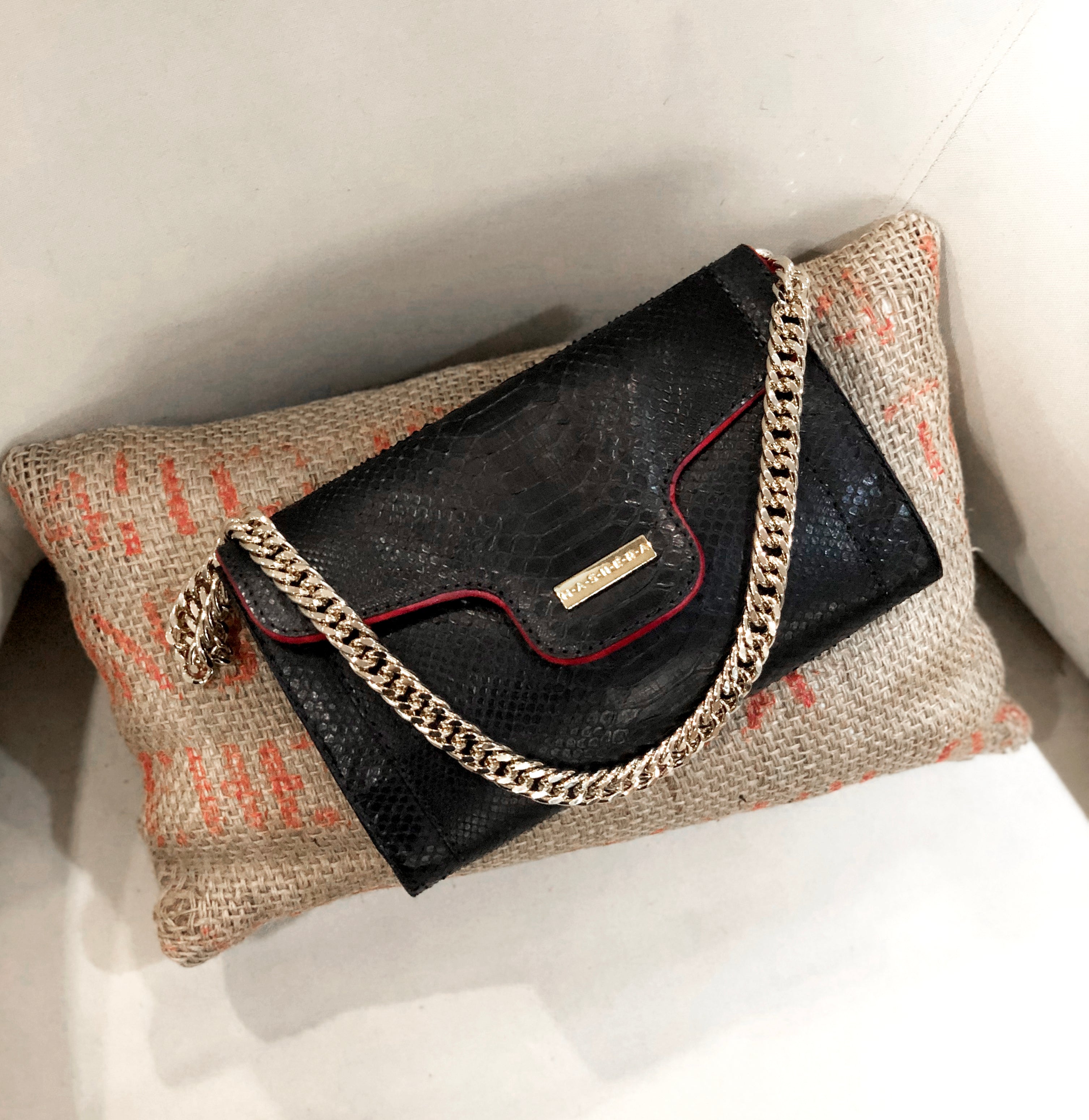 Clutch LISA en piel de pitón color negro e interior rojo gamuza - vista frontal con cadena dorada