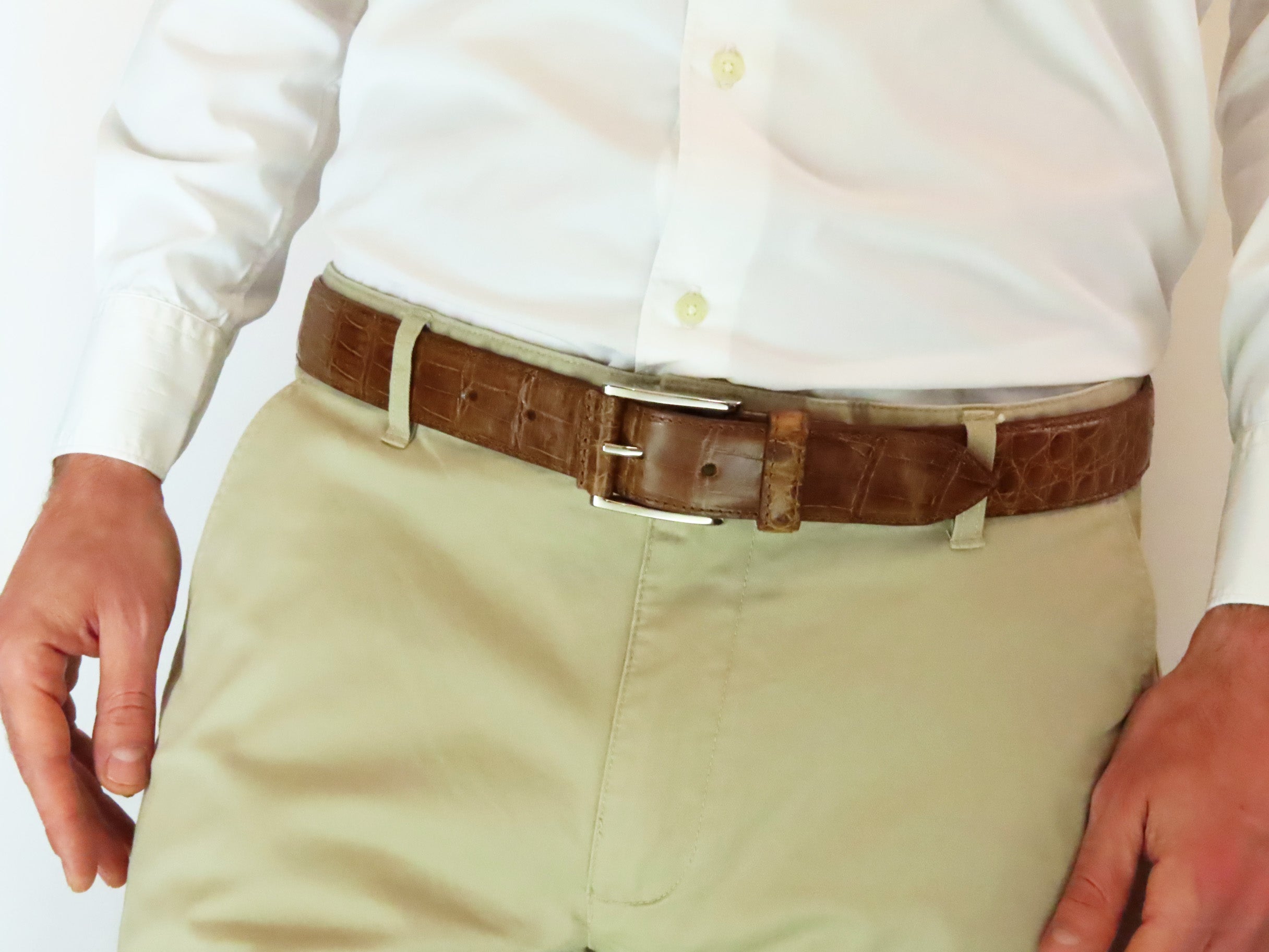 Modelo luciendo el cinturón ESPINO marrón sobre pantalón beige. Hebilla italiana con aplique en la misma piel de cocodrilo