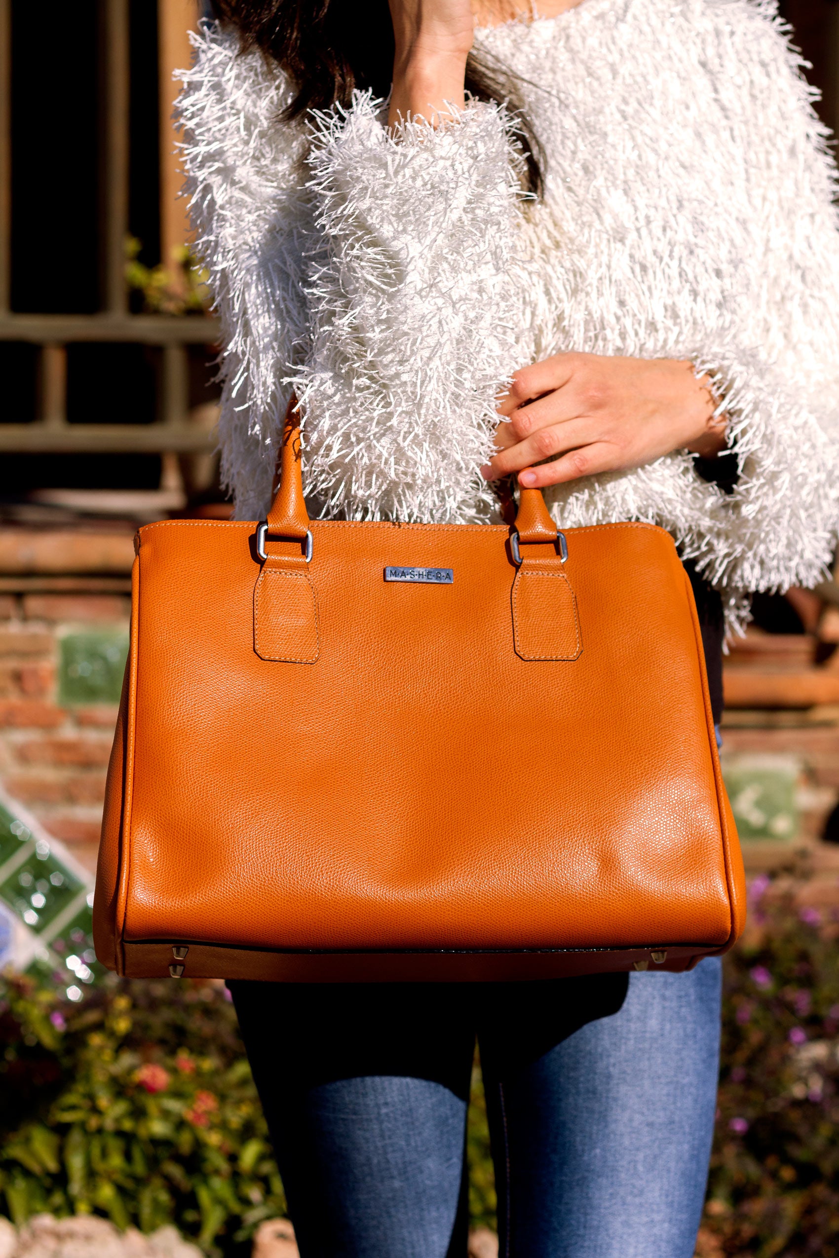 Modelo con bolso ERMITA naranja en piel - diseño amplio con manijas y bolsillos laterales invisibles