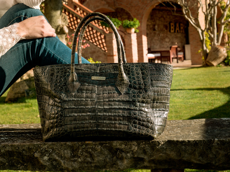 Modelo luciendo en un jardín el bolso LUCIANA en cocodrilo - shopping espacioso artesanal para el día a día
